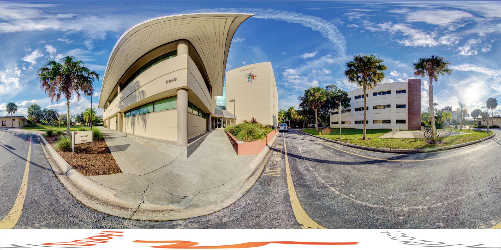 Panoramic view of Evans Library at Florida Tech, featuring modern architecture with curved and angular structures under a clear sky.